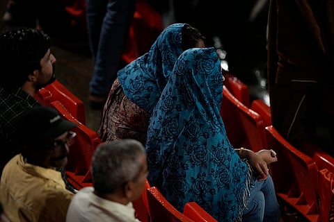Fans wait as rain delays the match